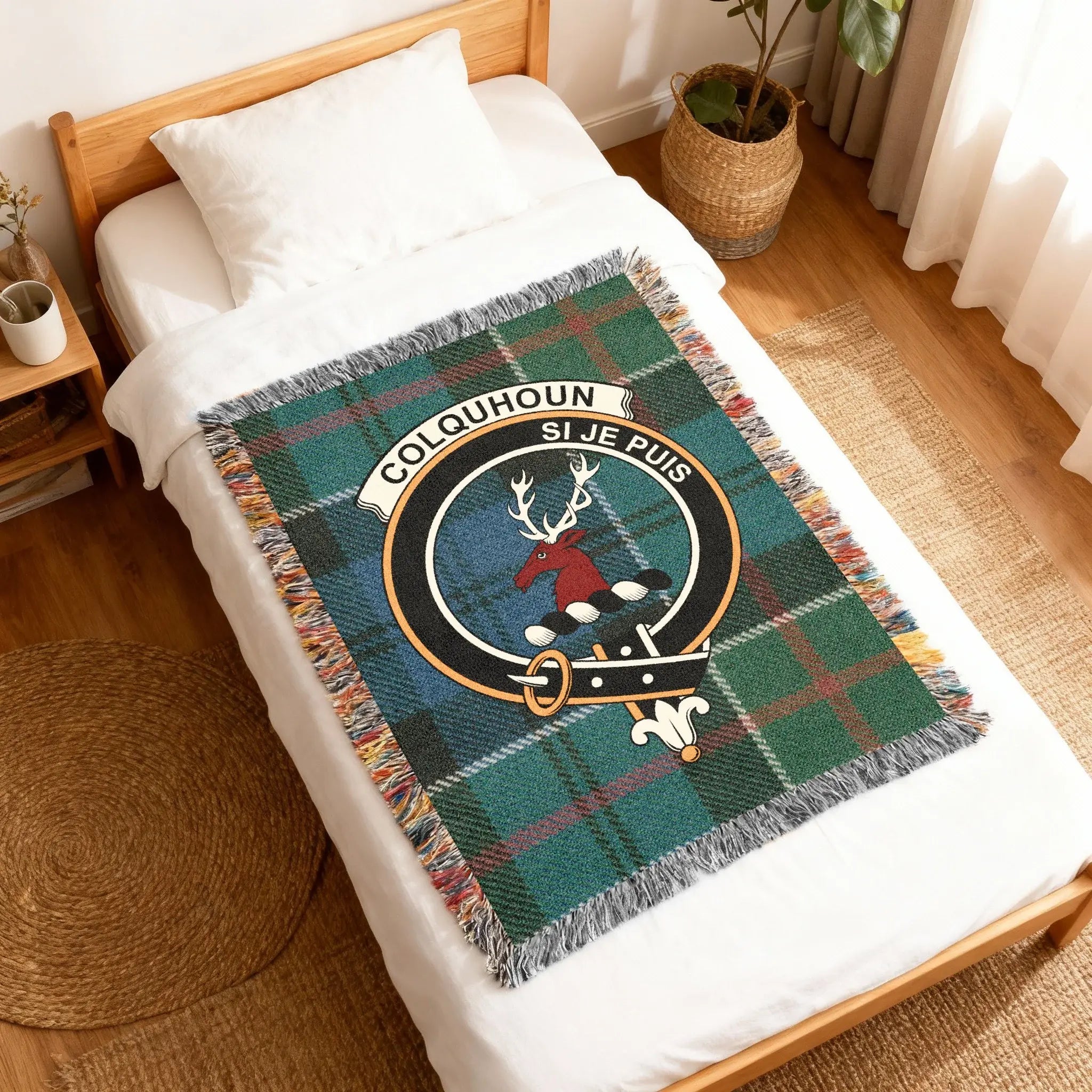 Colquhoun clan crest plaid woven blanket folded — tartan weave with stag heraldic design