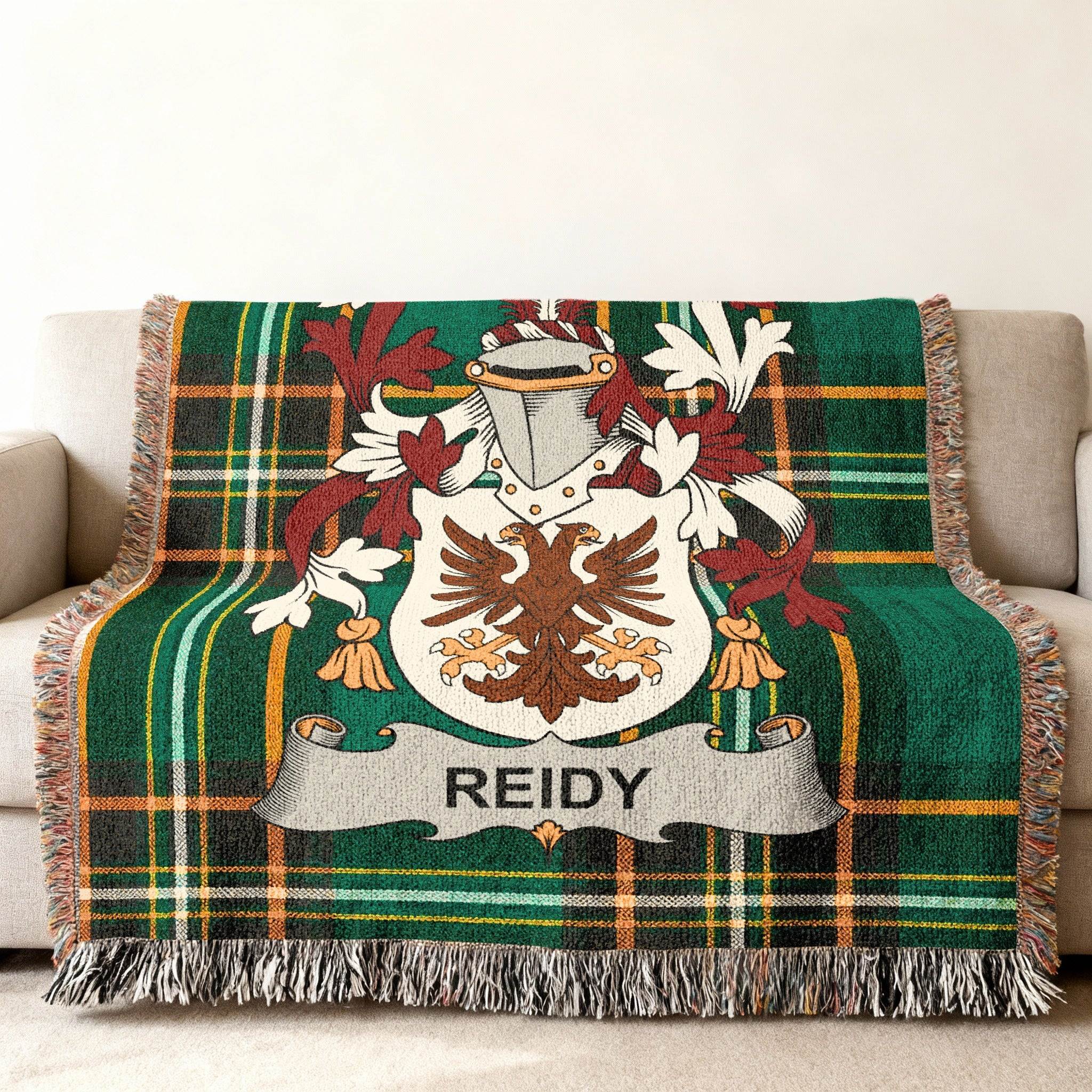 Green tartan blanket featuring a Reidy family crest on a couch.