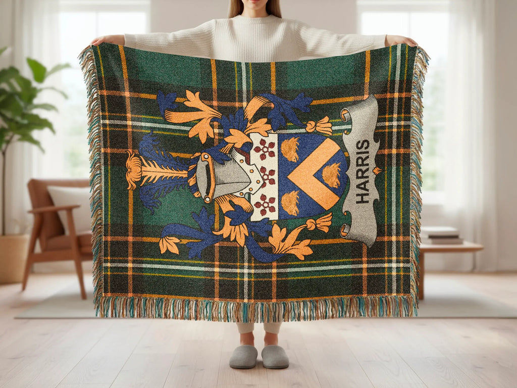Tartan throw with Harris crest and fringe, held by a person.