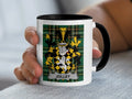 White mug with black rim and handle, featuring a Scottish tartan and the coat of arms for "Jolley".