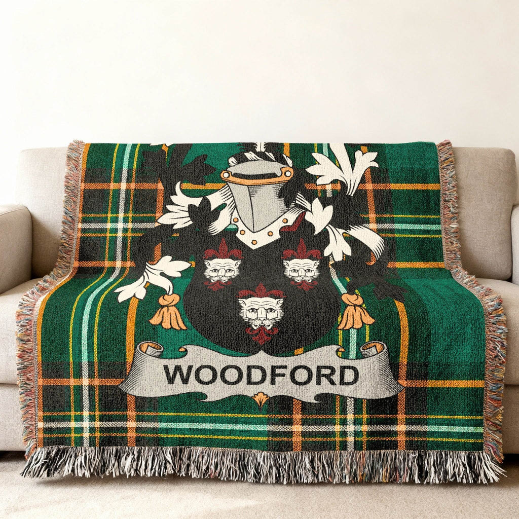 Woodford family crest on a green tartan throw blanket draped on a couch.
