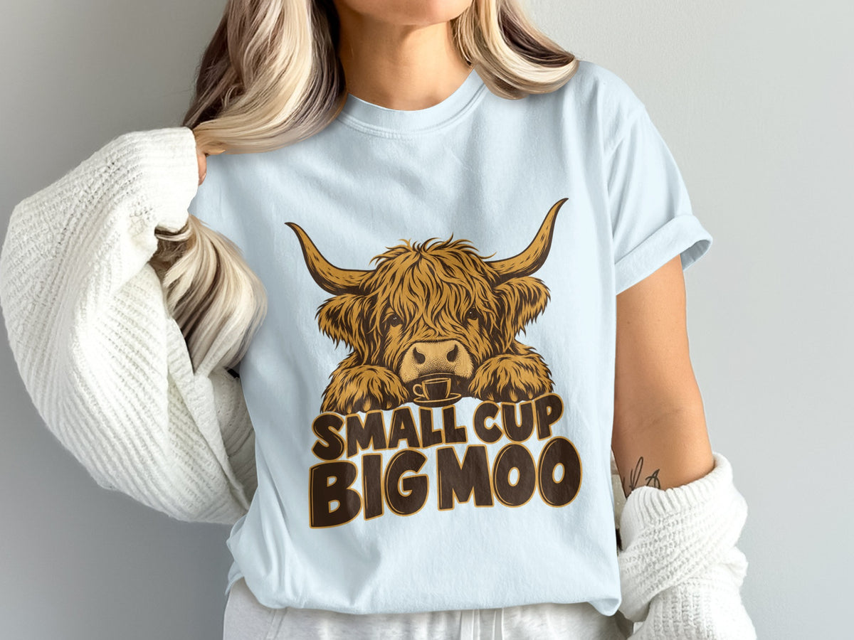 Model wearing the Small Cup, Big Moo Highland cow Comfort Colors T-shirt in Chambray