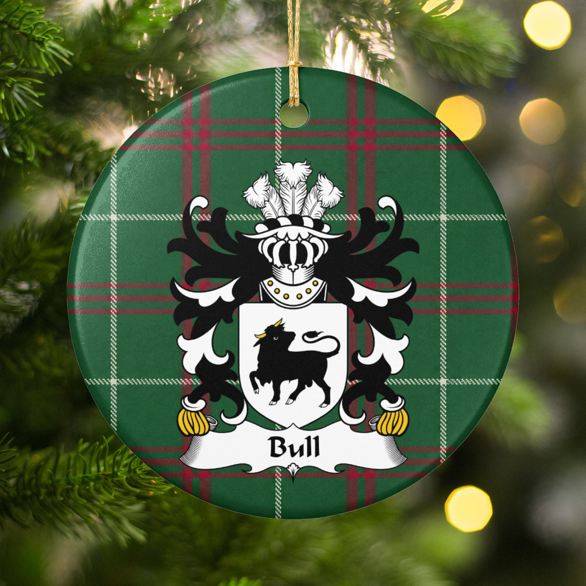 Bull ornament hanging among Christmas tree branches and warm lights; a black bull with gold horns on a white shield on Welsh national tartan.