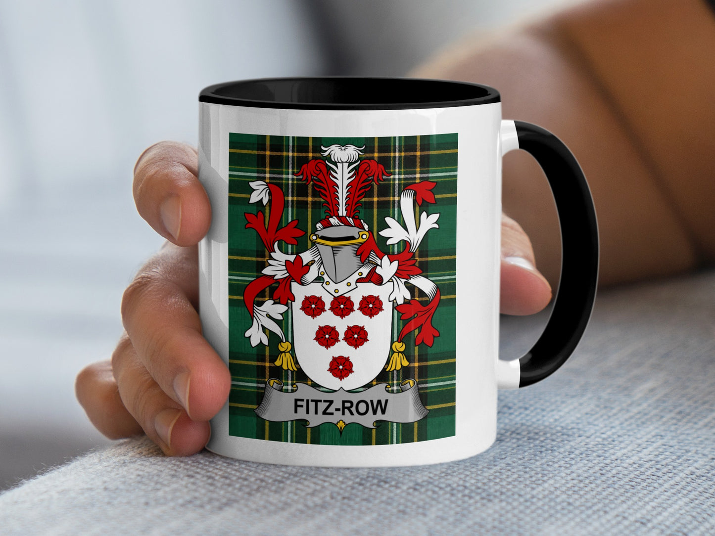 White mug with black rim displaying Fitz-Row family crest on tartan background.