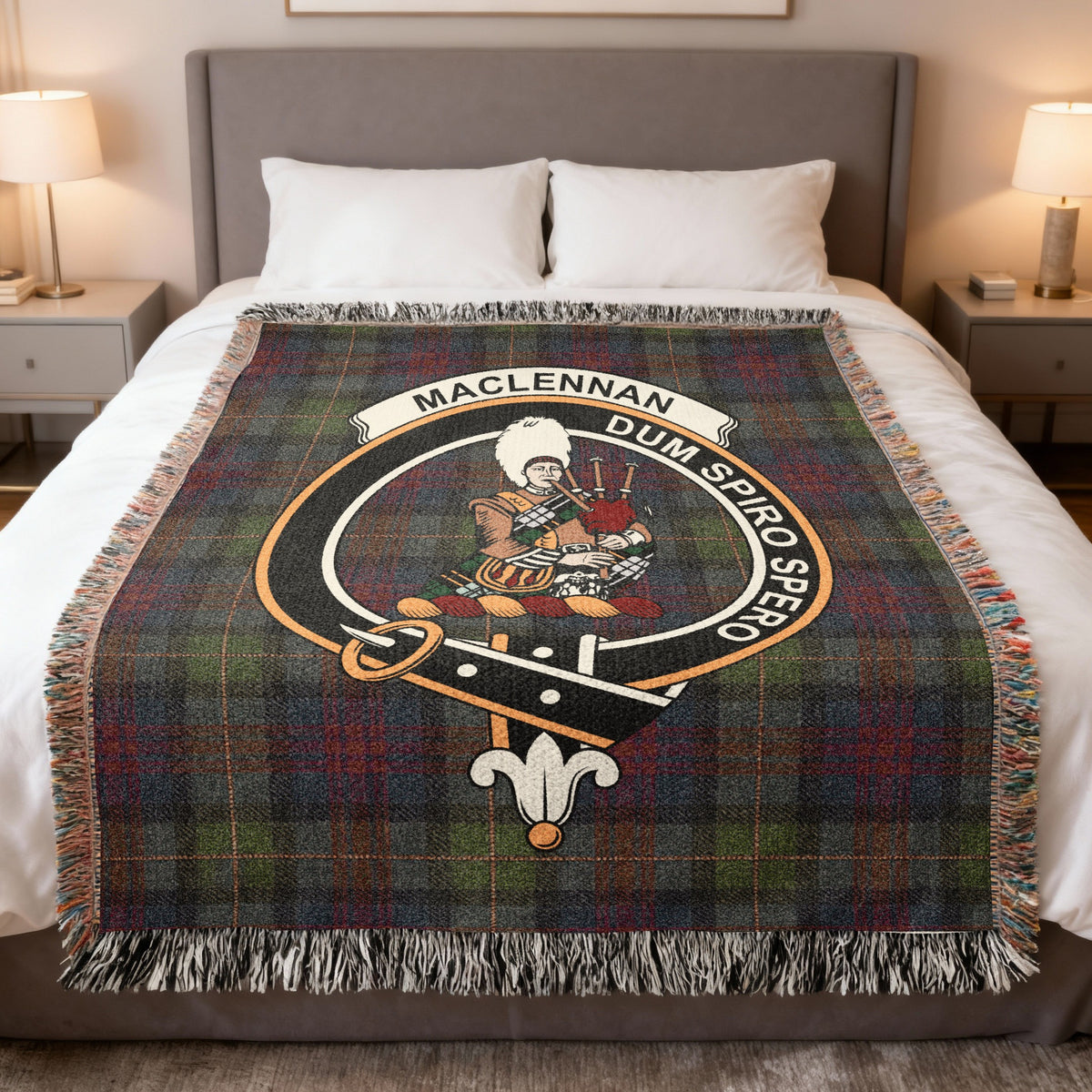 MacLennan woven blanket displayed on a bed, with a Highland piper on a muted green, blue and red tartan background