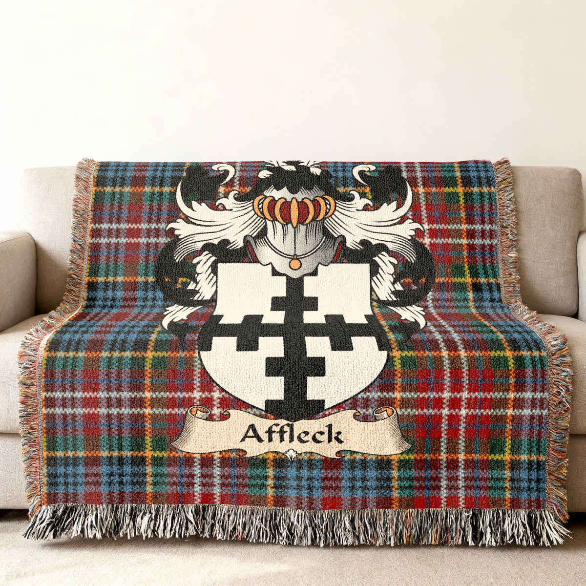 Affleck Scottish family shield woven blanket with Caledonia tartan background on a sofa