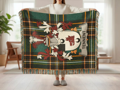Tartan blanket with Tennent family crest and tassels held by a person.