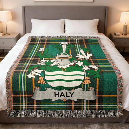 Green tartan blanket with HALY crest displayed on a bed.