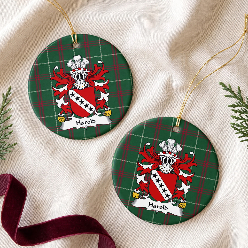 Two Harold ornaments on cream fabric with evergreen and burgundy ribbon; five black stars on a white diagonal band across a red shield on Welsh national tartan.