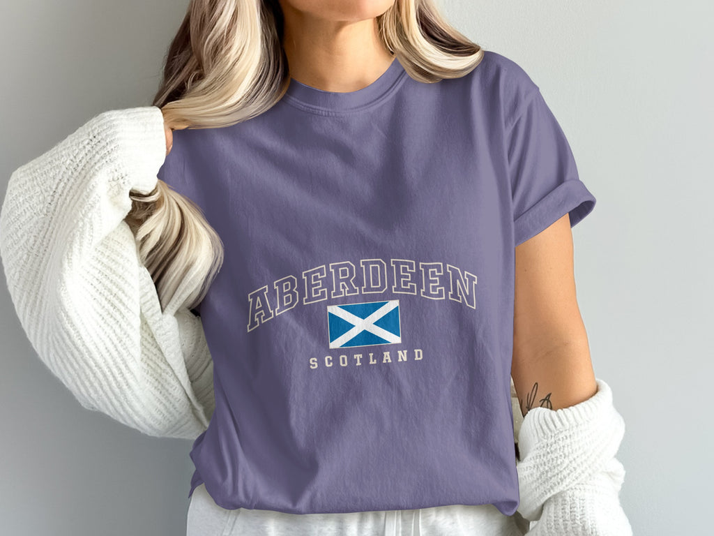 Model wearing the Grape Aberdeen Scotland Comfort Colors T-shirt with cream collegiate lettering