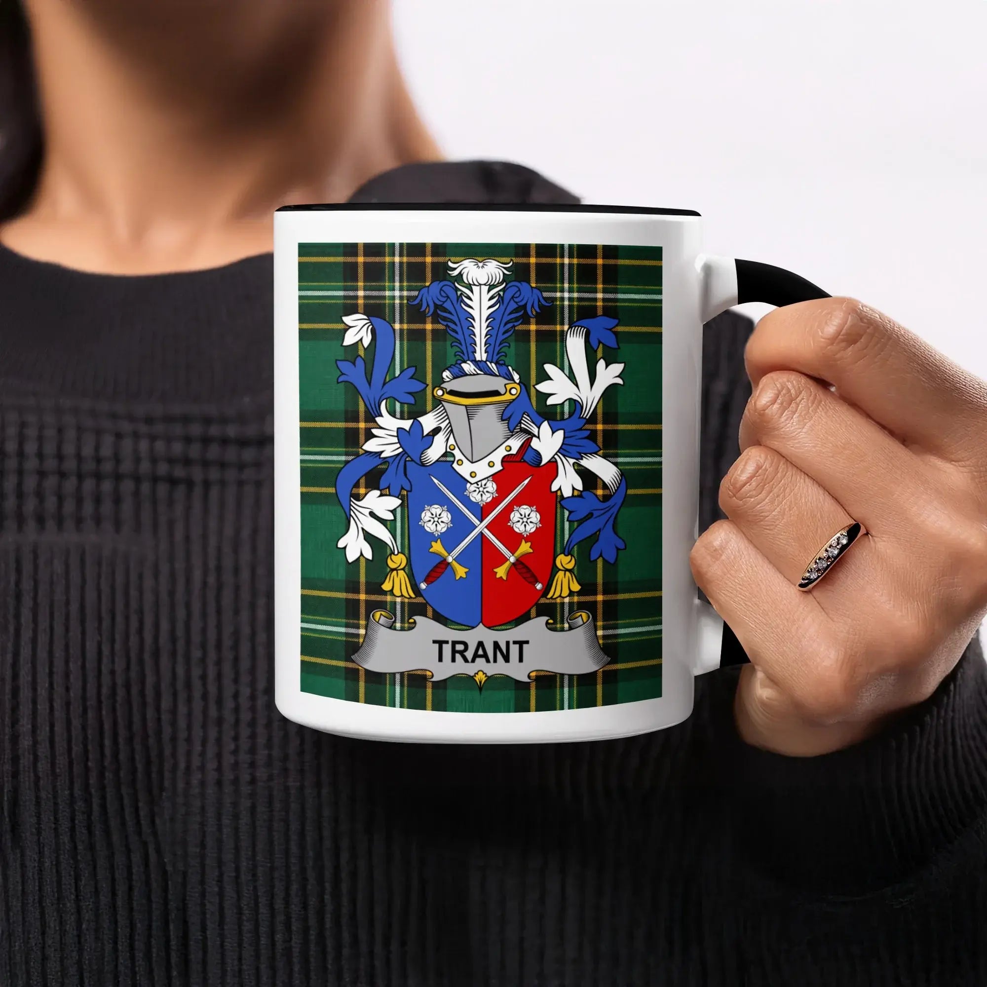 White mug with black handle featuring the Trant family crest on a tartan background.