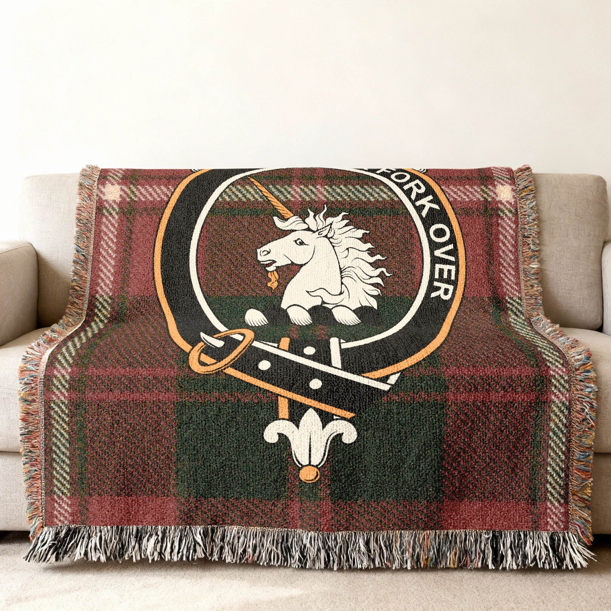 Cunningham tartan woven blanket draped — heraldic unicorn plaid crest, fringe edges