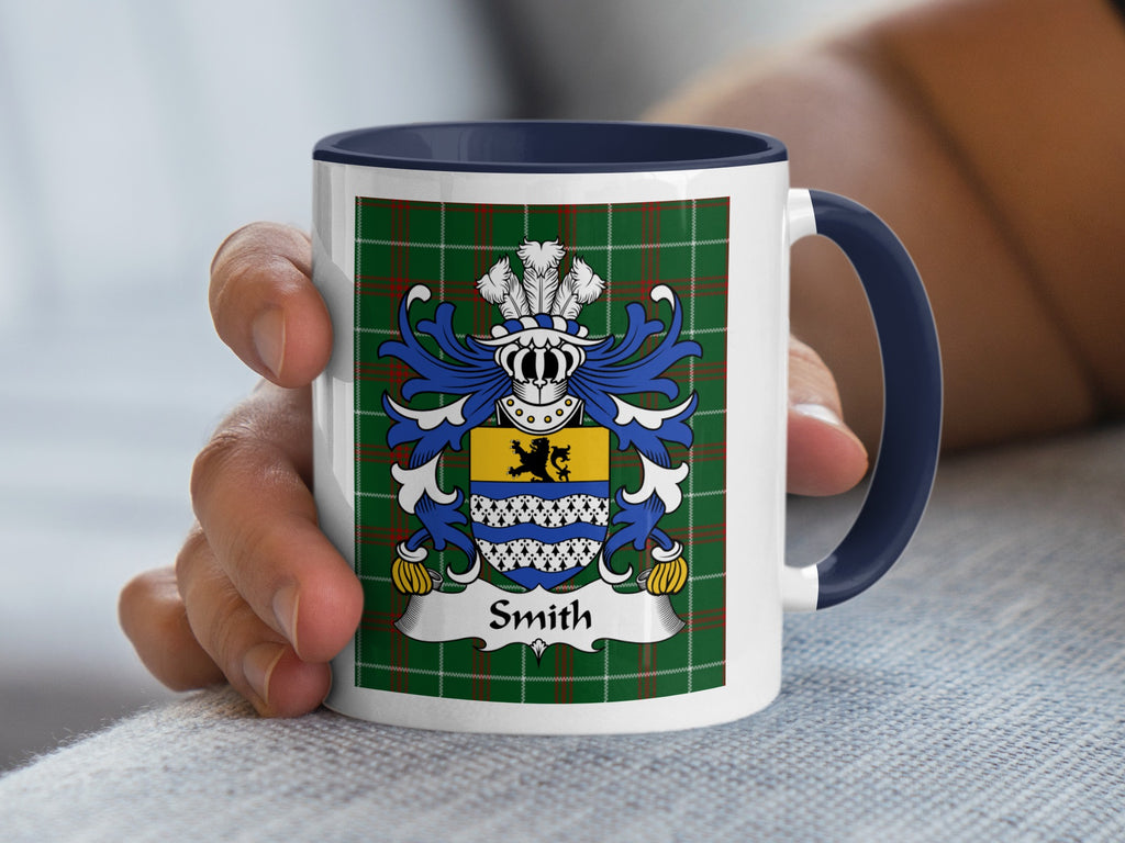 White mug with navy handle displaying the Smith family crest on a tartan background.