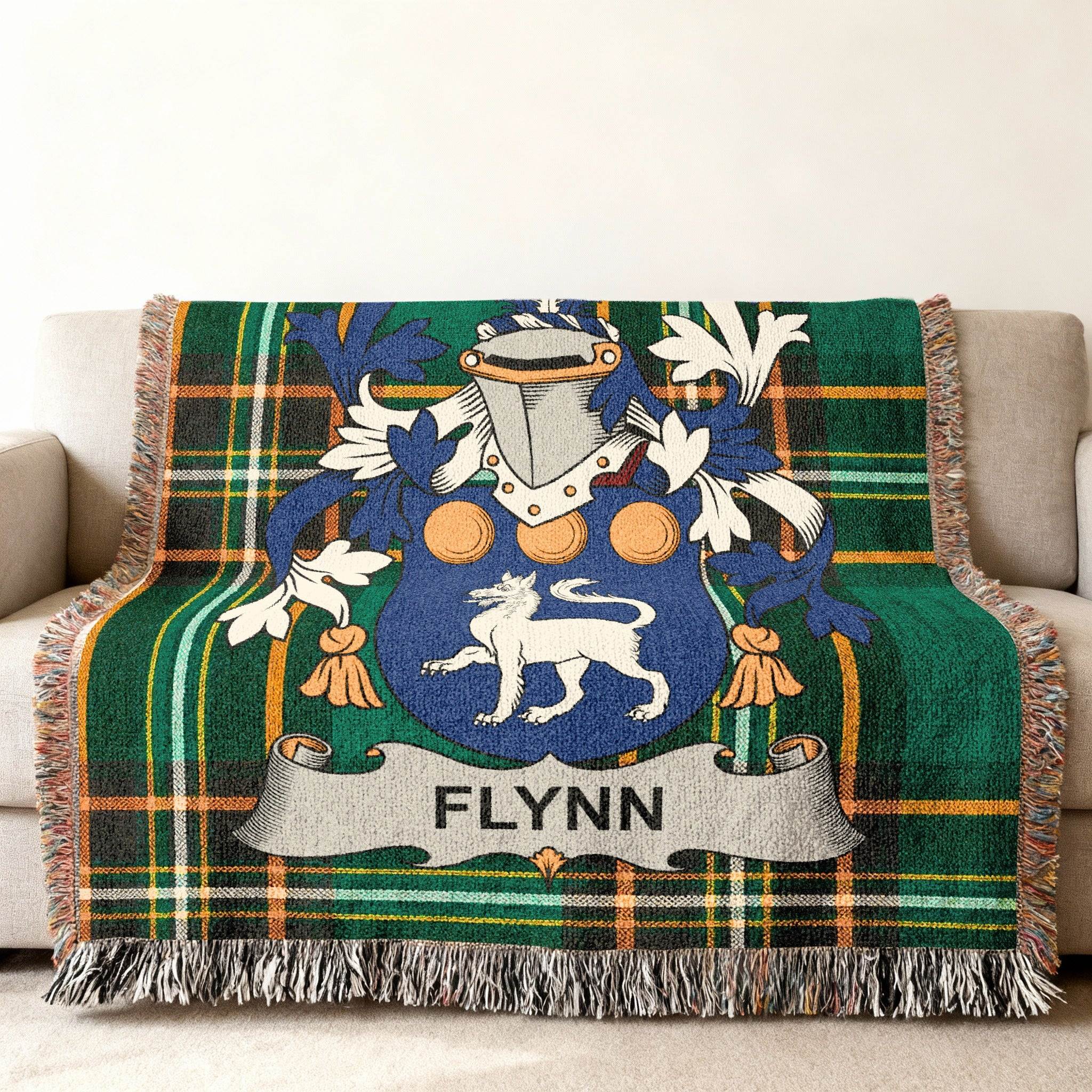 Green tartan blanket draped over a couch with the Flynn family crest.