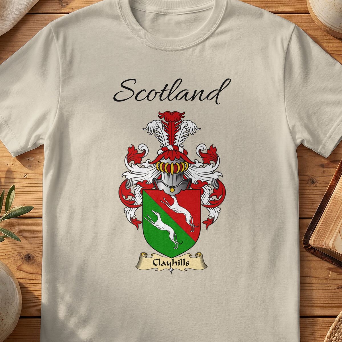 Sand Clayhills Scottish family shield T-shirt featuring white animals on a red-and-green shield