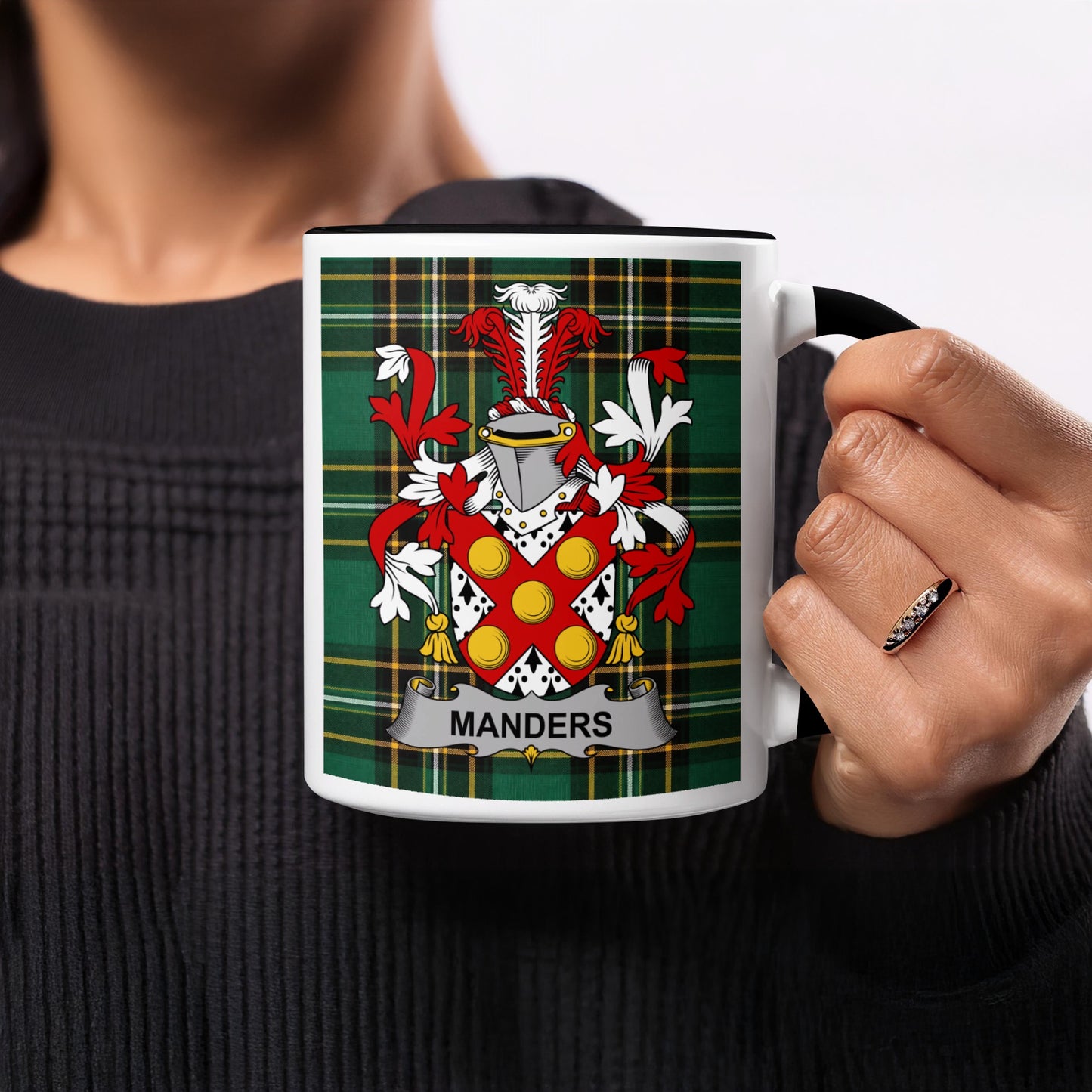 White mug with black handle featuring the Mander family crest on tartan background.