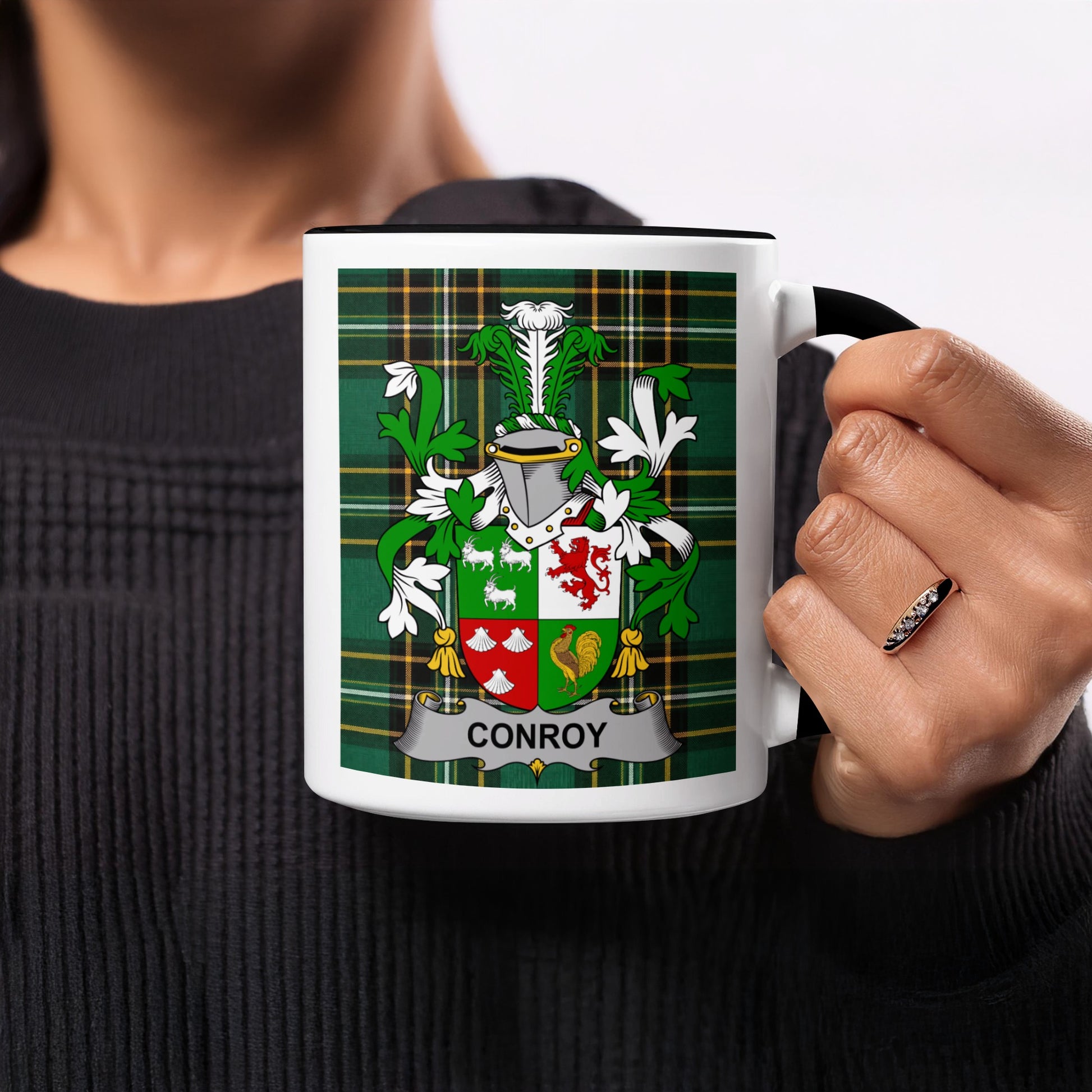 Black mug with Conroy family crest on tartan background.