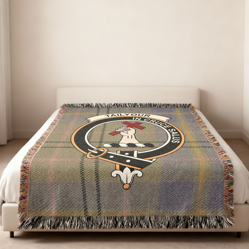 Tailyour Scottish woven blanket spread across a bed, showing the full crest design and tartan background