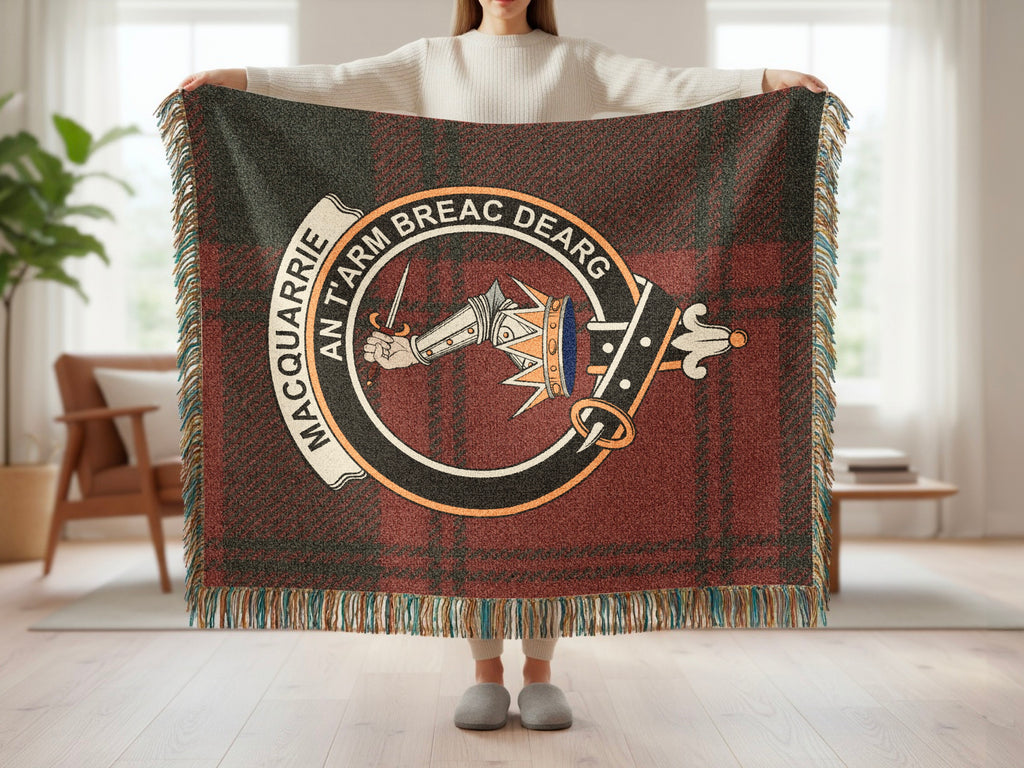 Person holding the MacQuarrie woven blanket to show the full design, tartan background and fringe