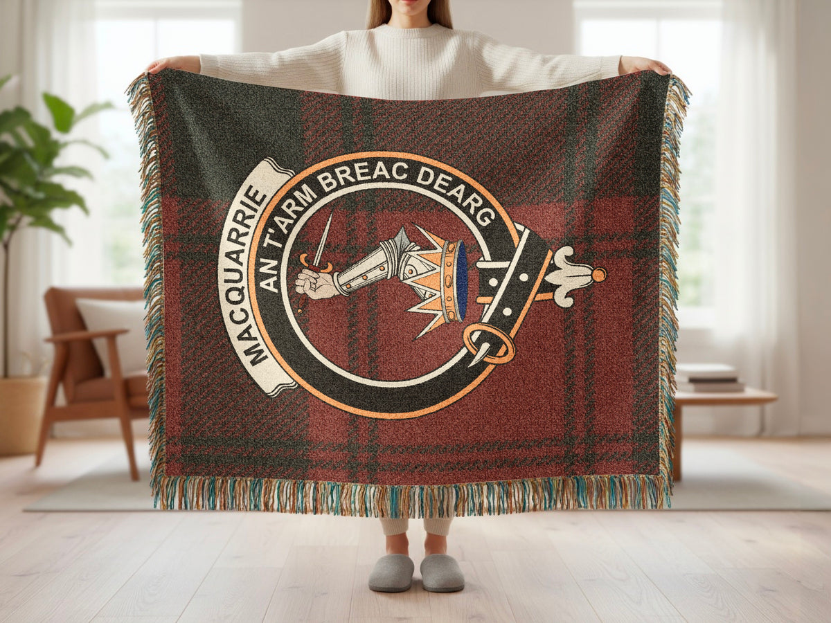 Person holding the MacQuarrie woven blanket to show the full design, tartan background and fringe