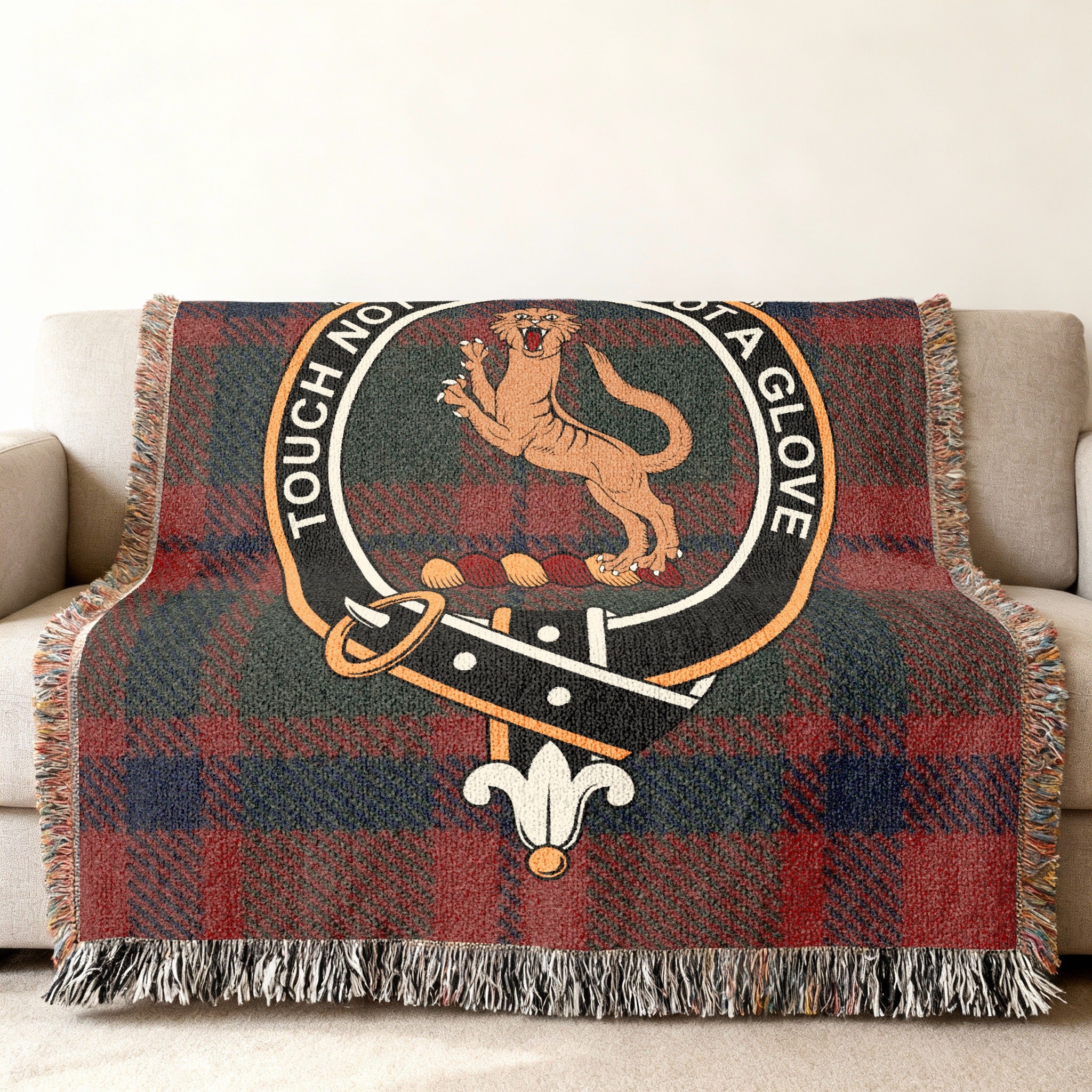 Mackintosh clan crest with wildcat and motto on tartan woven blanket