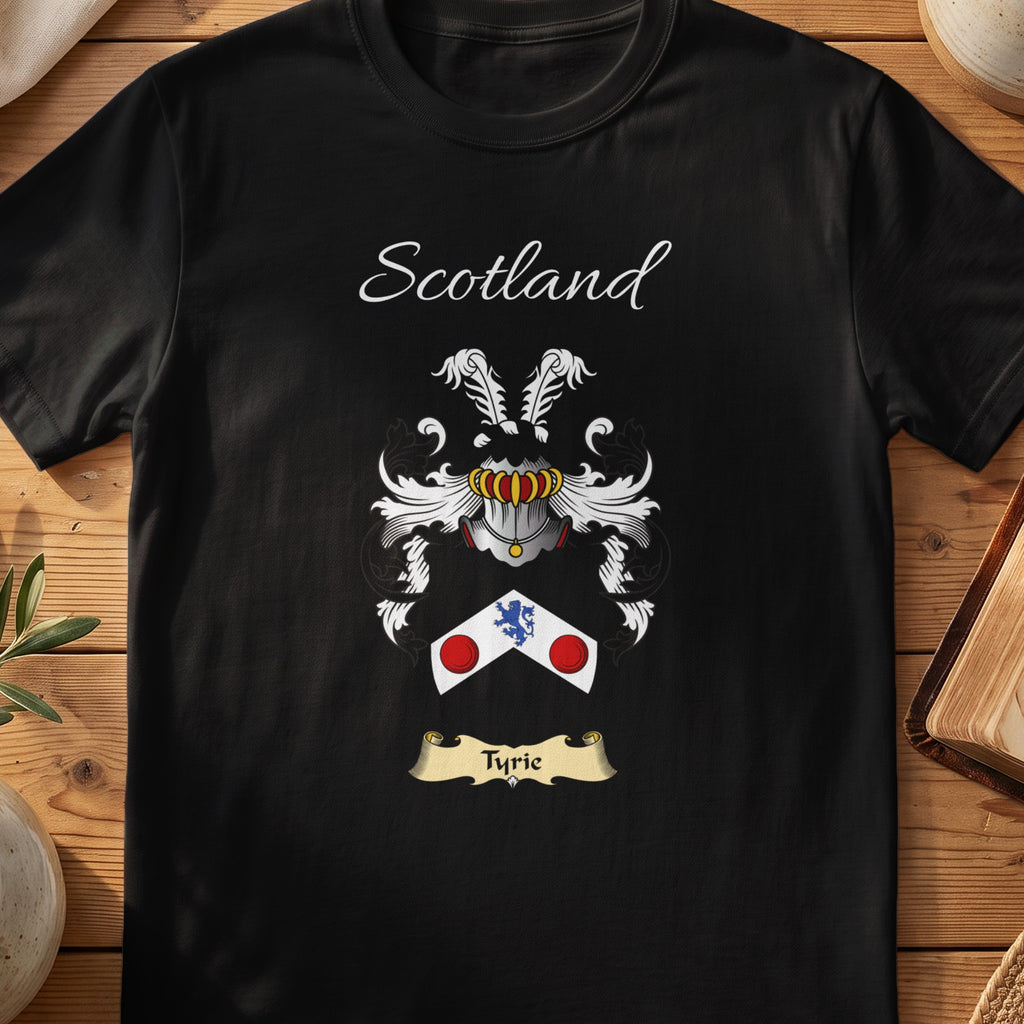 Black Tyrie Scottish family crest T-shirt laid flat, showing “Scotland” above a black-and-silver shield with blue and red circular accents.