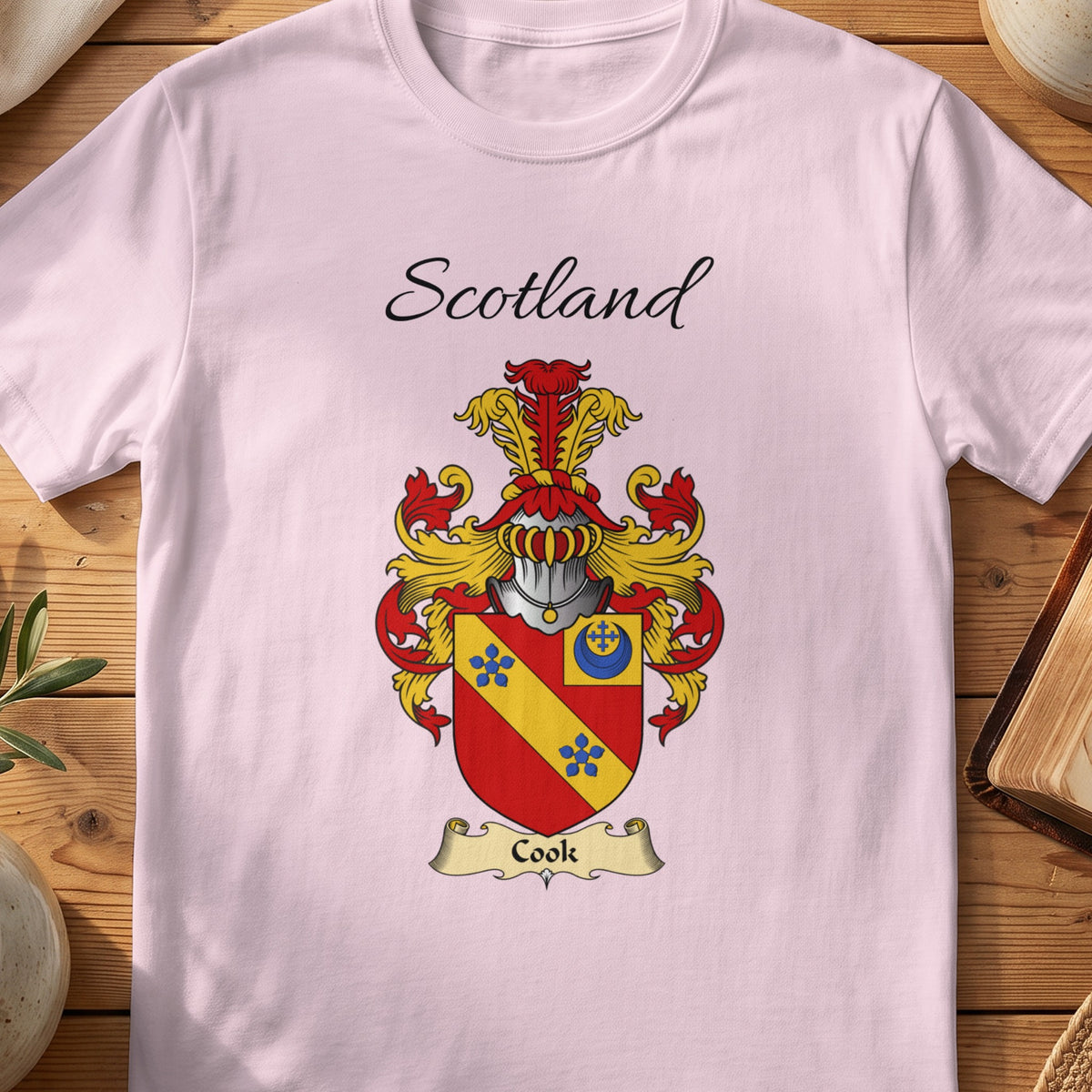 Light Pink Cook Scottish family shield T-shirt featuring a gold diagonal band with blue flowers on red