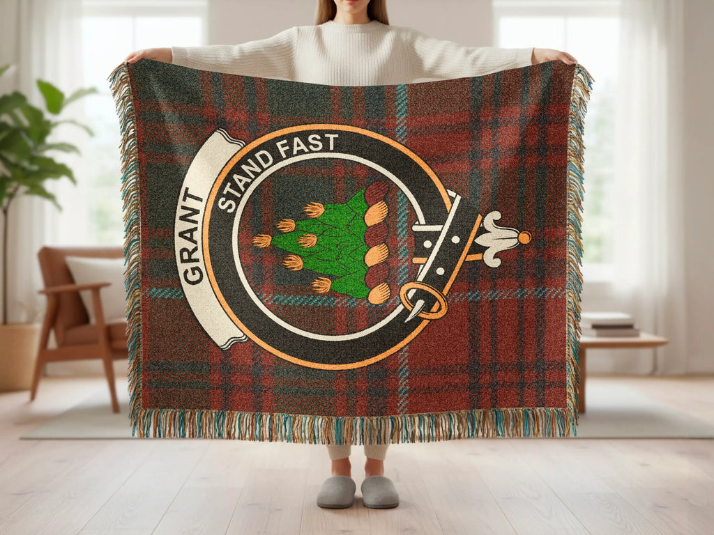 Grant Stand Fast tartan woven blanket draped — red-green plaid with heraldic crest, fringe edges