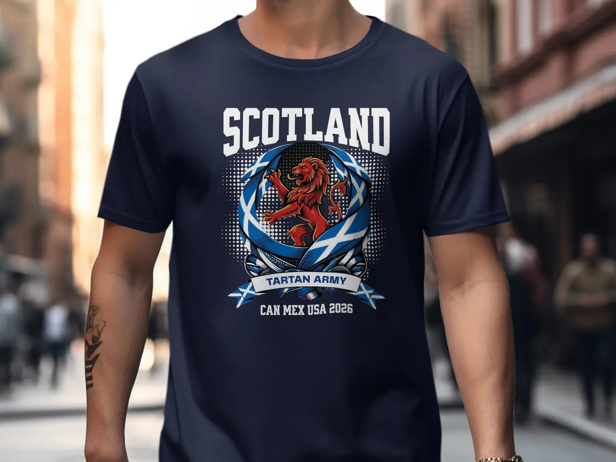 Navy t-shirt with "SCOTLAND" and a lion crest, "TARTAN ARMY", "CAN MEX USA 2026".