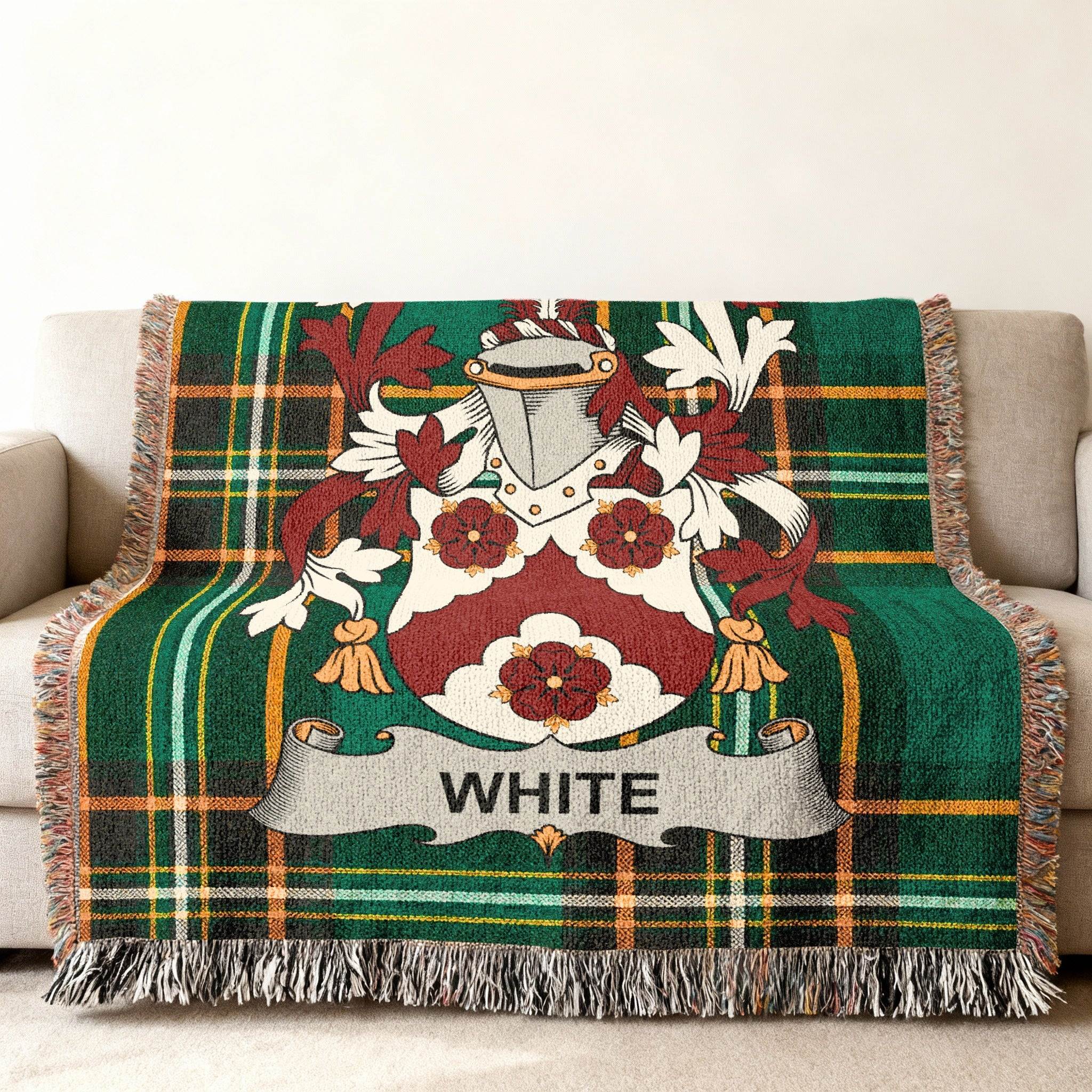 Green tartan blanket with White family crest, draped on a couch.