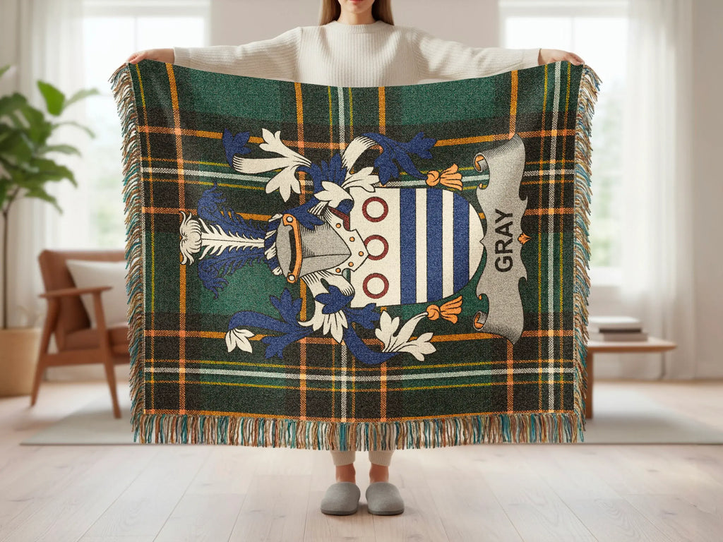 Gray tartan blanket with clan crest, held open.