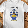 White Farie Scottish family shield T-shirt featuring a white anchor on blue beneath a gold top band