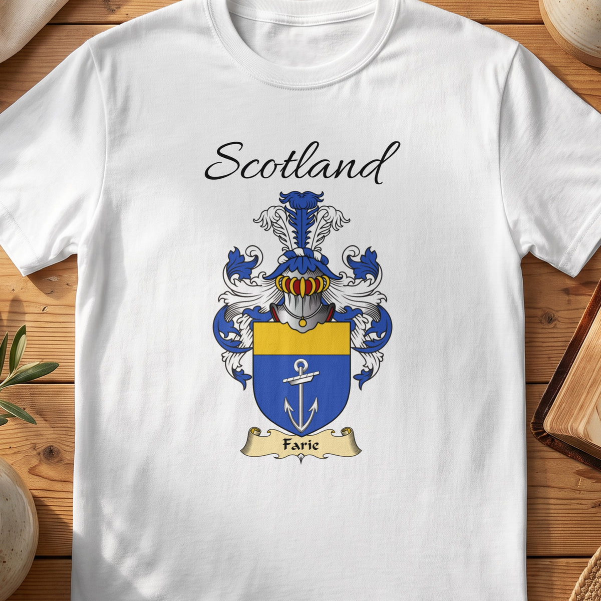 White Farie Scottish family shield T-shirt featuring a white anchor on blue beneath a gold top band