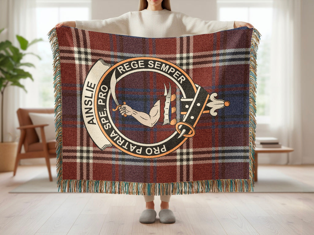 Person holding the Ainslie woven blanket to show the full design, tartan background and fringe