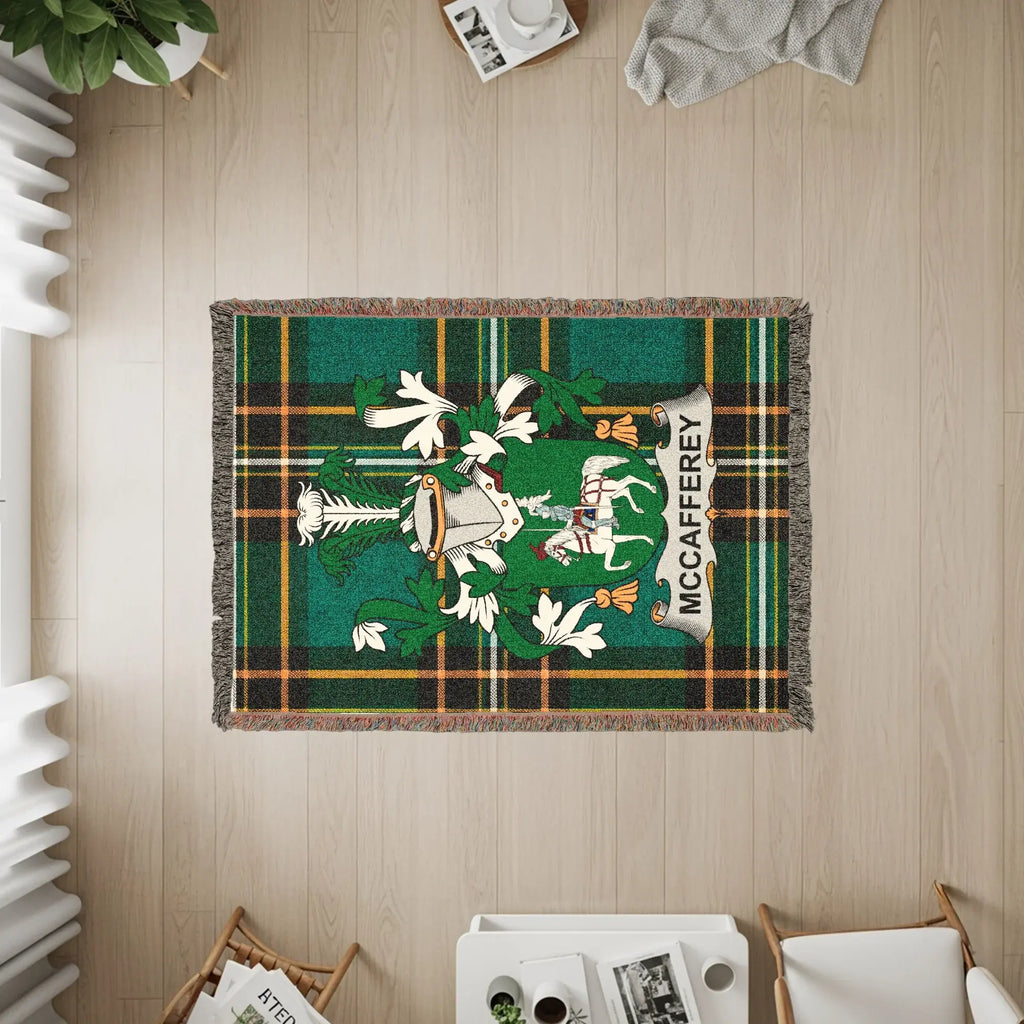 Green tartan blanket with McCaffrey crest, laid on a wooden floor.