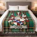 Tartan blanket with Lynam family crest on a bed.