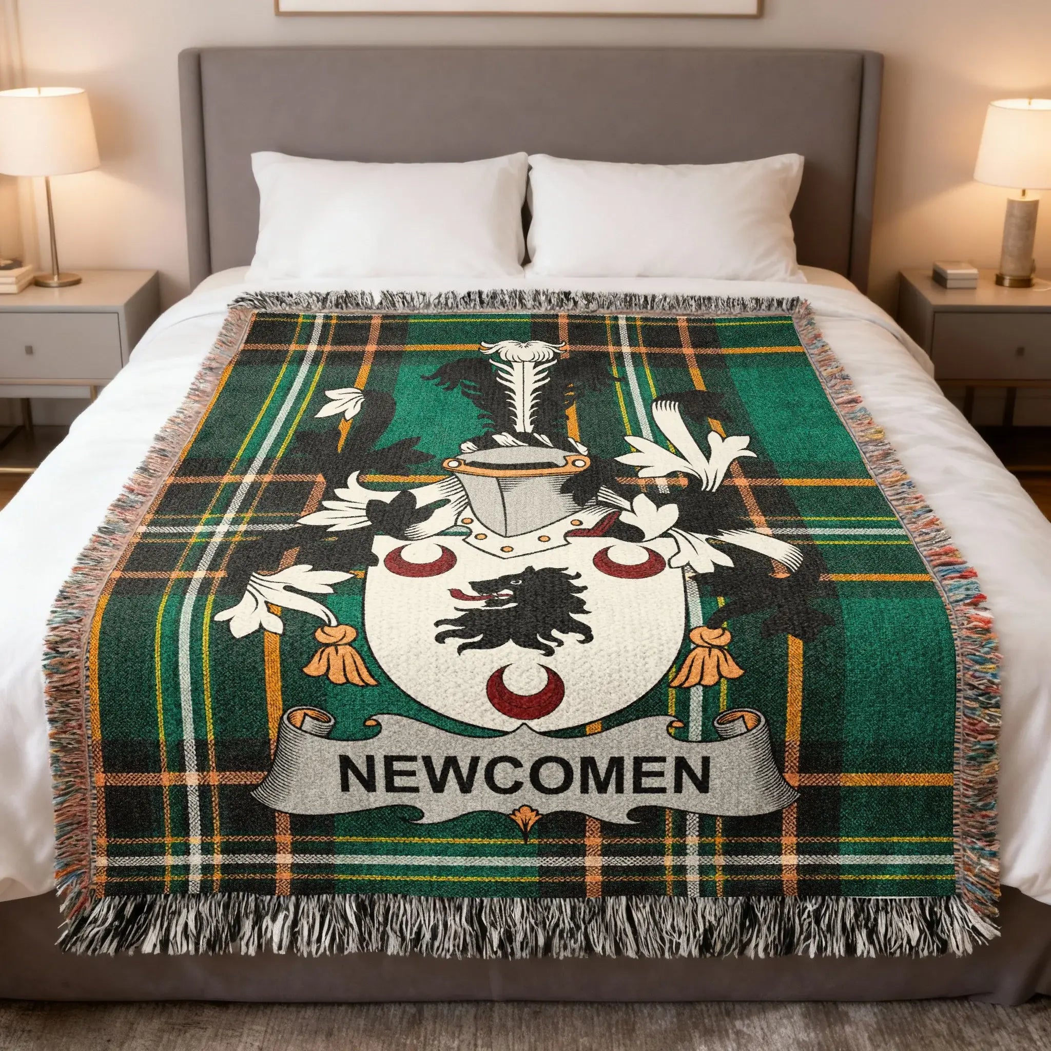 Newcomen coat of arms on a green tartan woven blanket on a bed.