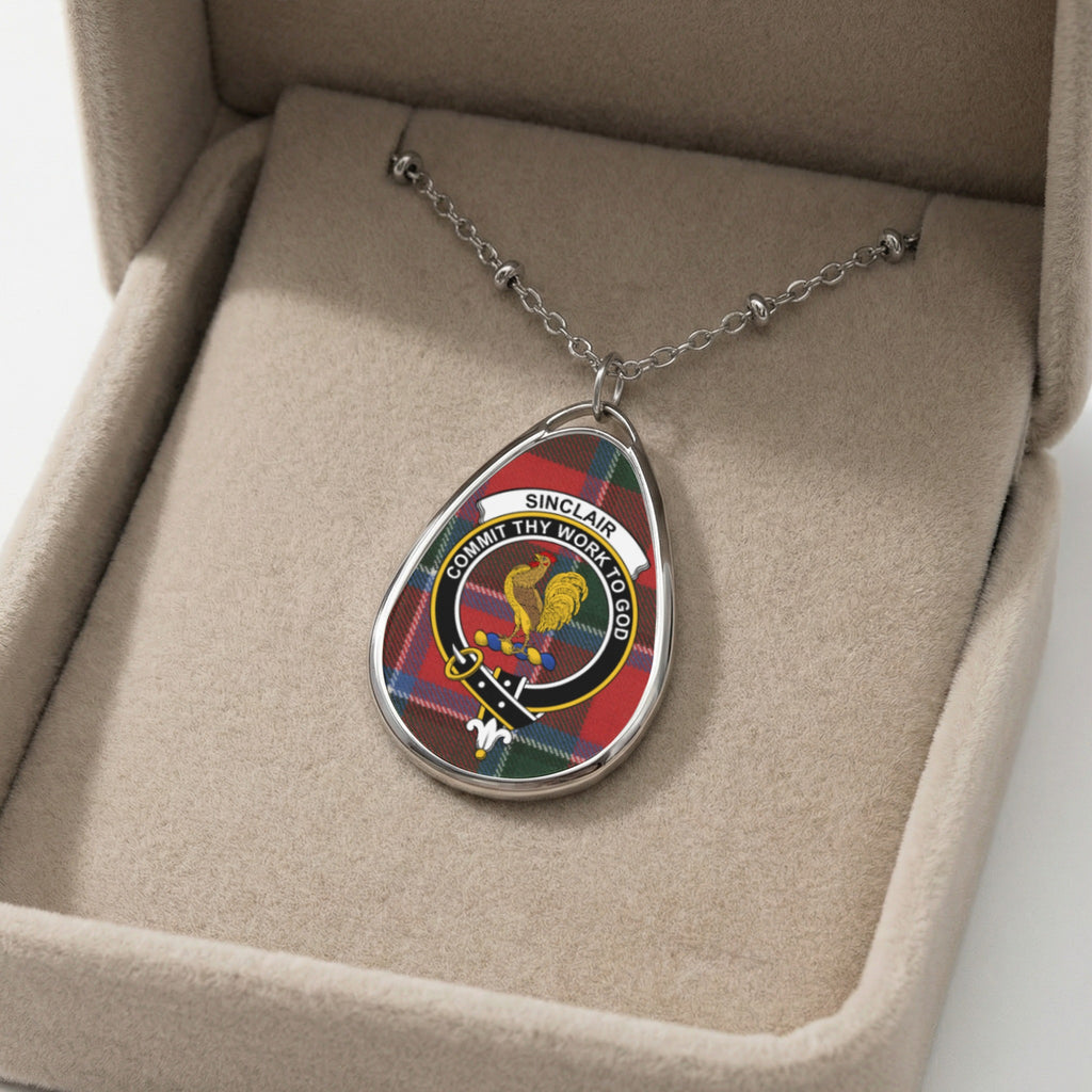 Sinclair clan crest pendant with motto "Commit Thy Work to God" on tartan background.