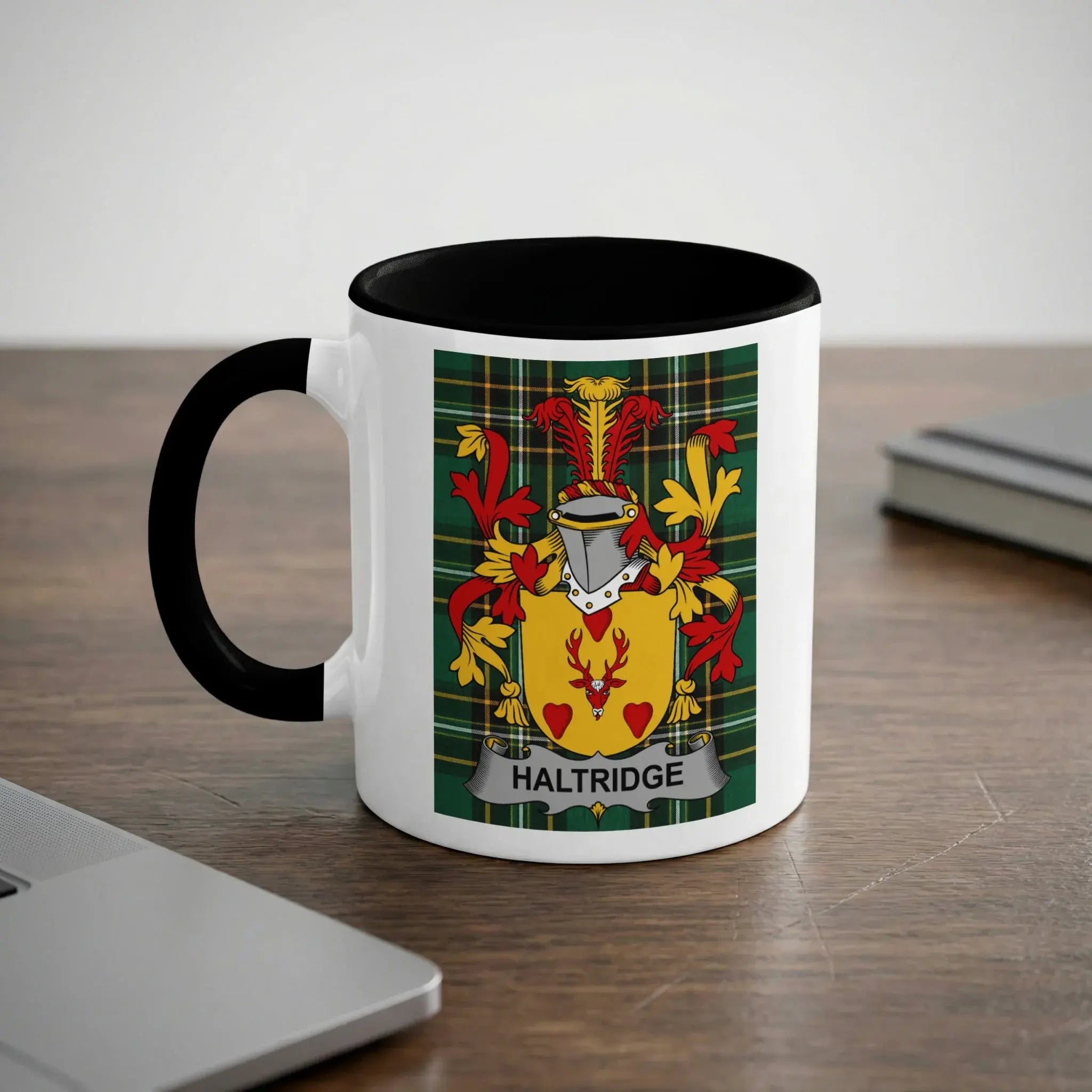 White mug with black handle featuring the Haltridge family crest on a plaid background.