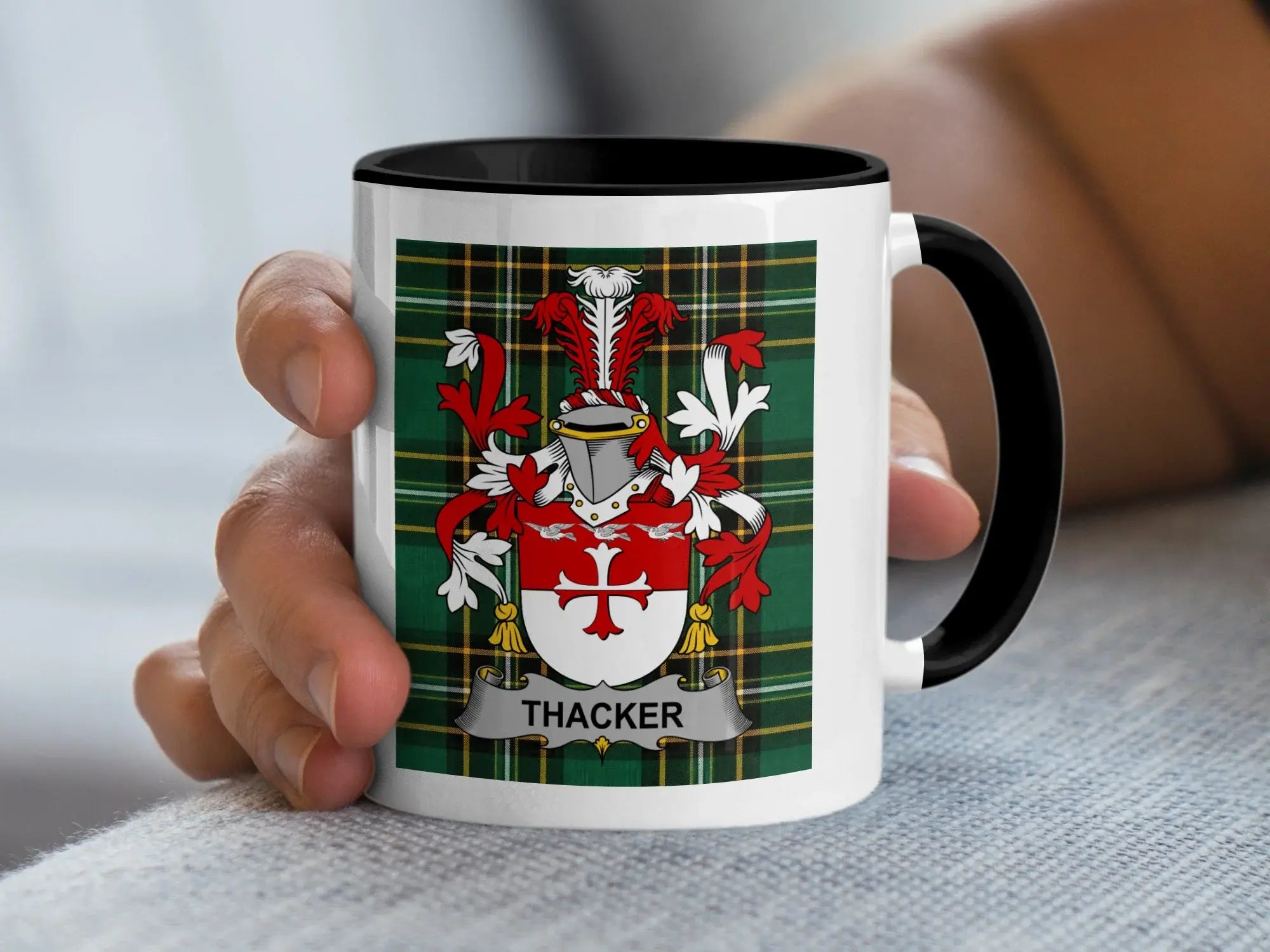 White mug with black rim, featuring the Thacker family crest on a tartan background.