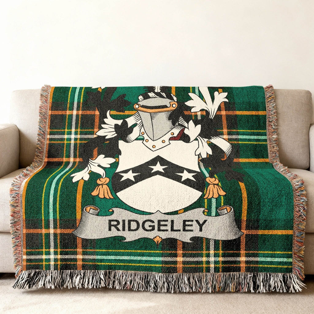 Ridgeley family crest on a green and black plaid woven throw blanket.