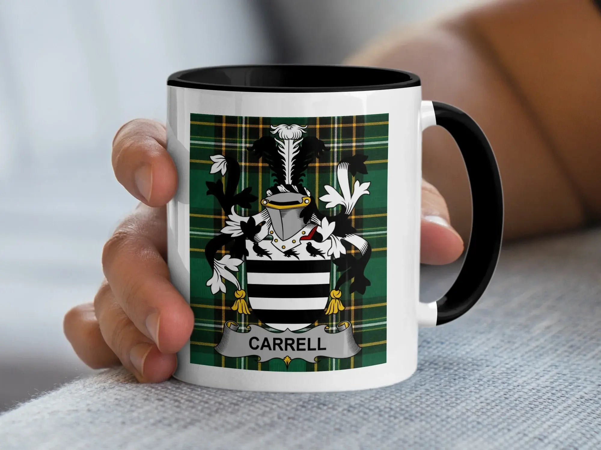 White mug with black handle, featuring the Carrell family crest on a tartan background.