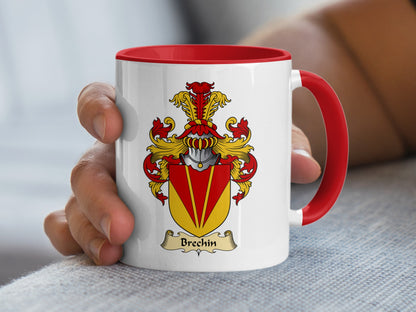 White mug with red handle featuring Brechin family crest on a grey textured surface.