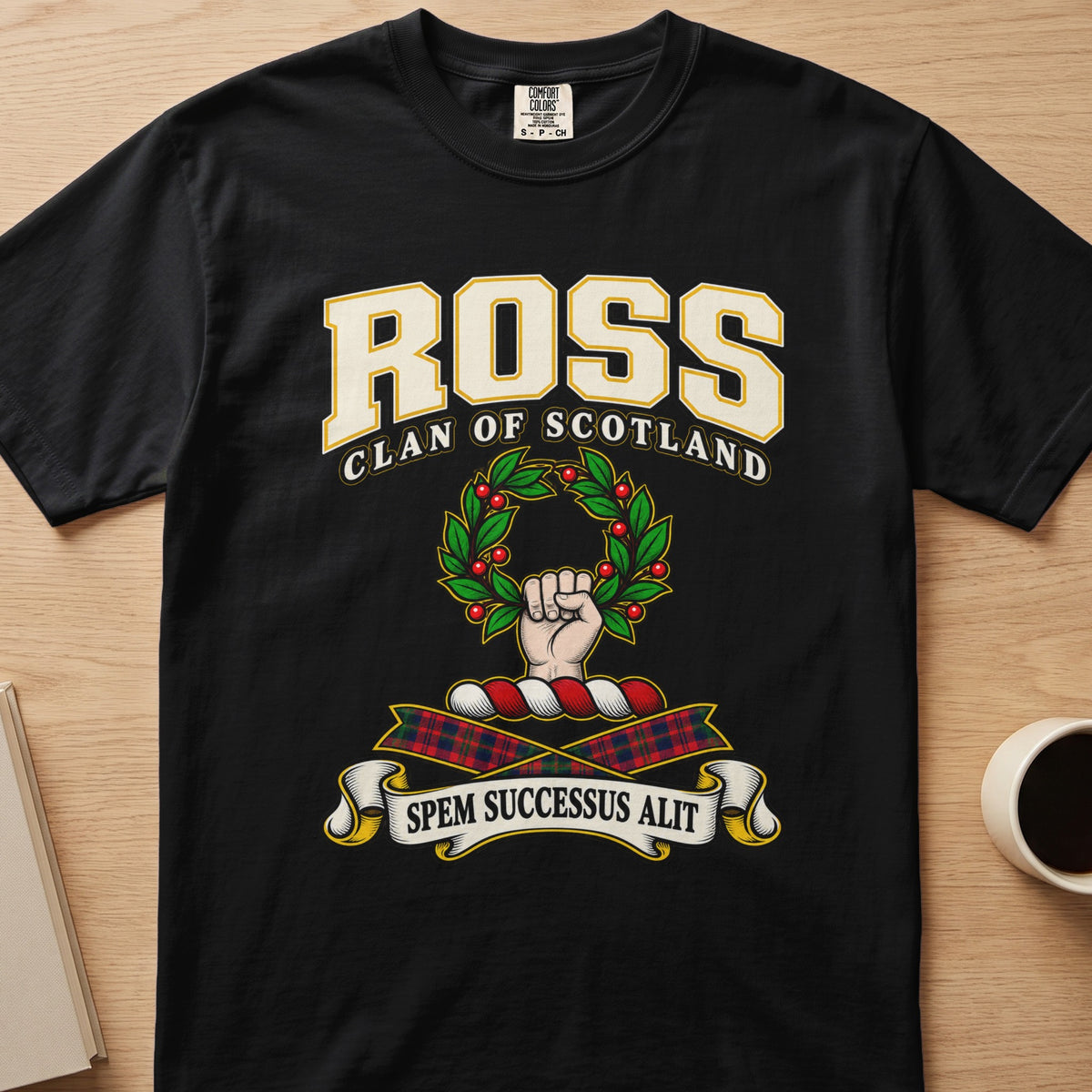 Ross raised hand holding a green wreath graphic on a black Comfort Colors T-shirt, front view