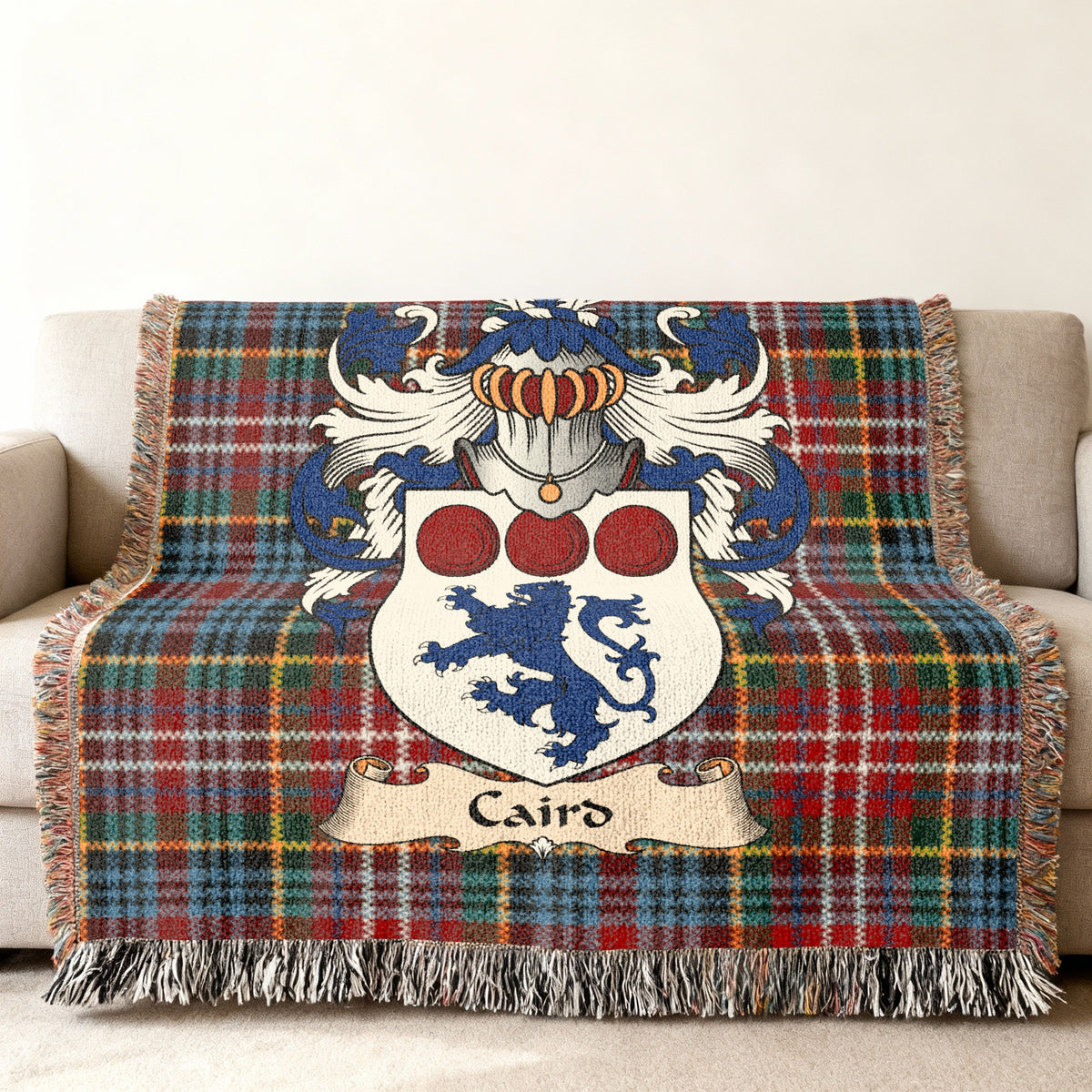 Caird family crest emblem on a Caledonia tartan woven blanket