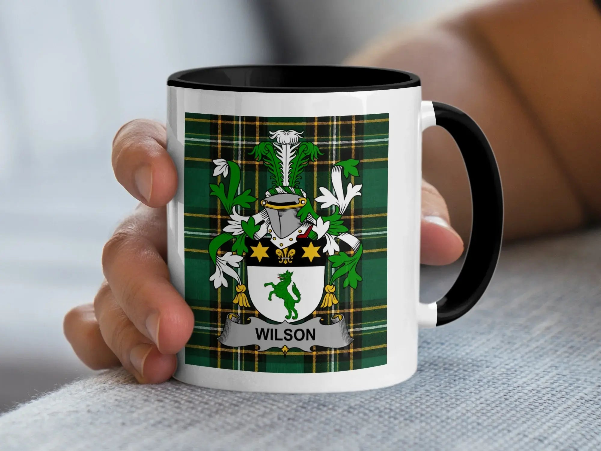 White mug with black rim featuring a green plaid background and the Wilson family crest.
