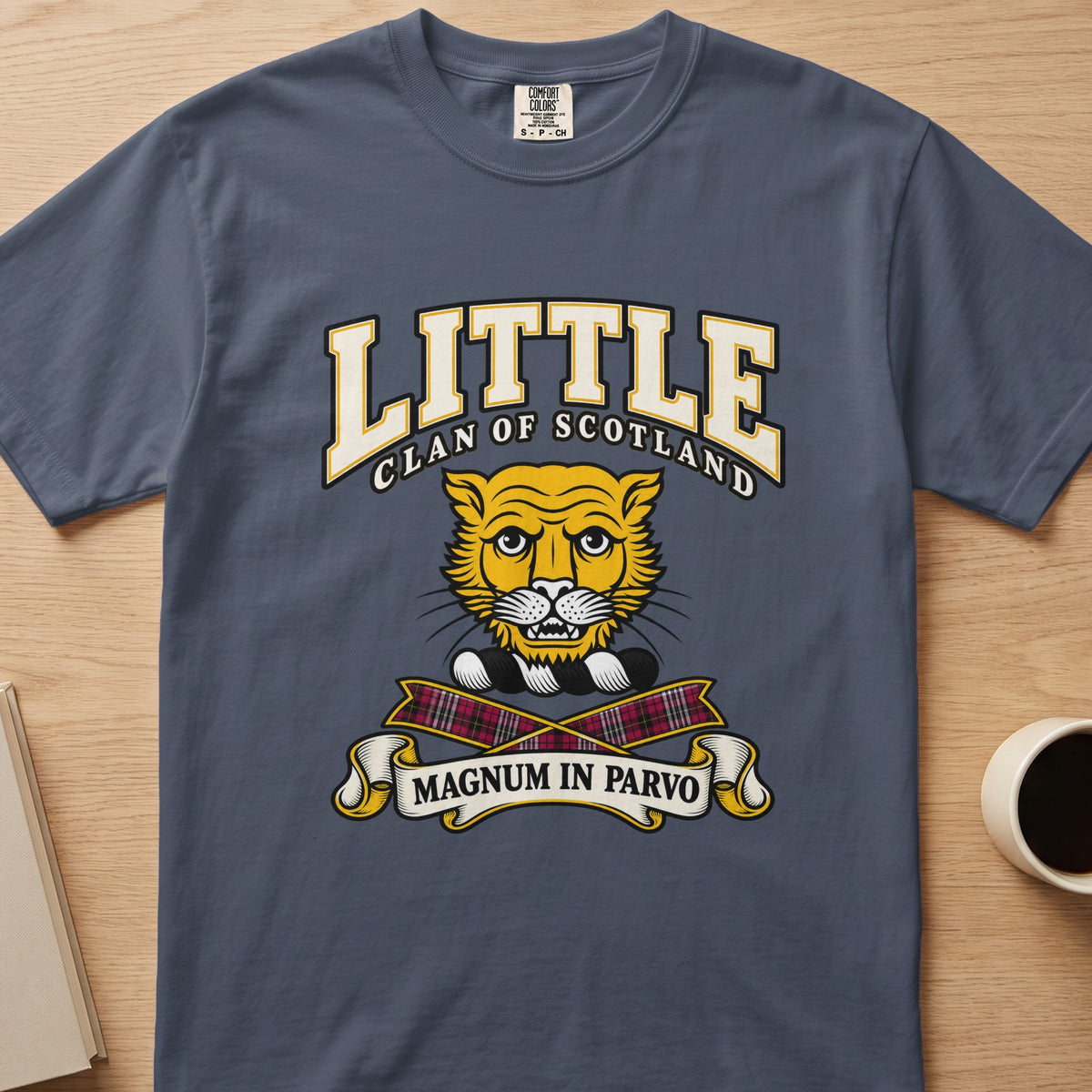 Little clan crest with gold cat face on a slate blue Comfort Colors T-shirt, front view