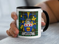 White mug with black handle featuring the Bevens family crest on a tartan background.