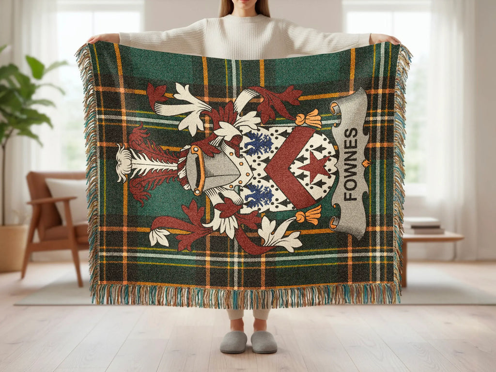 Green tartan blanket with Fownes crest displayed by person.