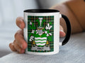 White mug with black rim featuring a green tartan pattern and a coat of arms with "HALY" banner.